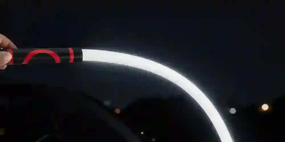 Gibek świeci w wygiętym łuku nocą, w kadrze widoczna dłoń trzymająca uchwyt