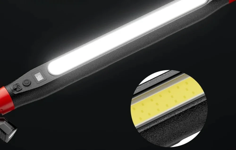 Zbliżenie na panel lampy: port USB-C pod klapką, okrągły przycisk, wyświetlacz poziomu naładowania i początek długiego okna światła COB na czarnym, ziarnistym korpusie