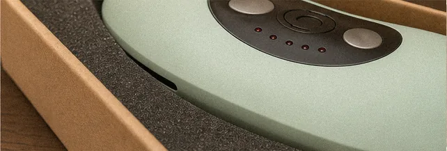 Róg kartonowego pudełka z urządzeniem na piankowej wkładce, wieko poza kadrem.