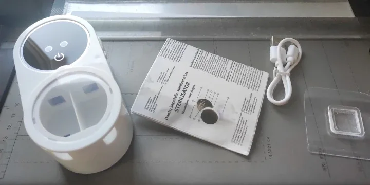 Zdjęcie od kupującego: zawartość zestawu rozłożona na blacie — urządzenie, biały kabel USB-C, płytka montażowa i złożona instrukcja