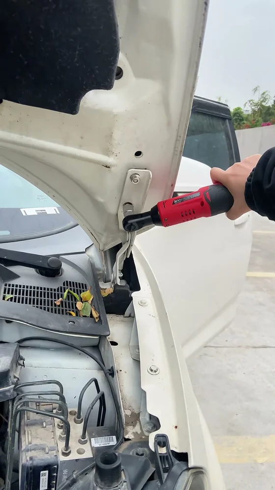 Klatka z nagrania @Chris Auto Parts: praca akumulatorową grzechotką kątową — odkręcanie śrub zawiasu maski