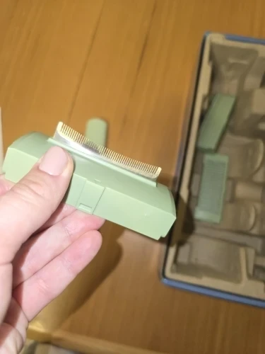Nasadka trzymana w dłoni nad kartonem, w którym leżą pozostałe nasadki z zestawu.