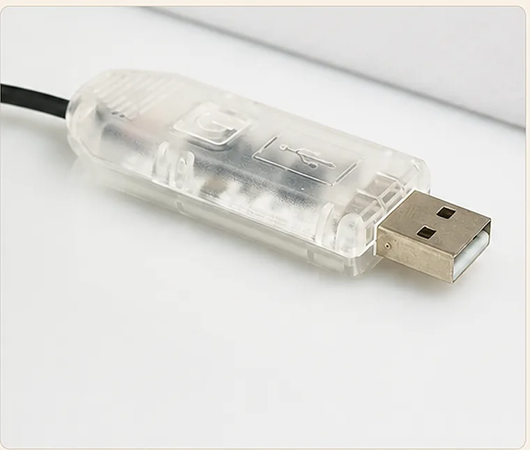 Przezroczysty sterownik z wtykiem USB-A leżący na jasnym blacie